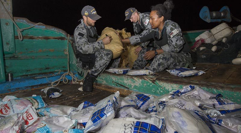 Royal Australian Navy sailors Leading Seaman Adam Cook, Able Seaman Dylan Canderle and Able Seaman Lydia Ratu Kavoa label and bag parcels of seized narcotics on a vessel in the Middle East. Photo by Leading Seaman Tom Gibson.