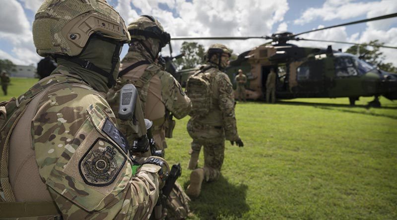 Queensland Police Service Special Emergency Response Team tactical operators await the all-clear signal during familiarisation drills with an Australian Army MRH90 helicopter in preparation for the 2018 Commonwealth Games. Photo by Sergeant W Guthrie.