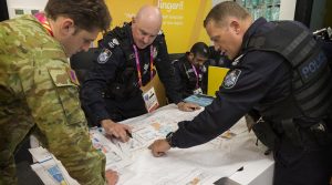 Queensland Police Service officers, Acting Senior Sergeant Mike Cahill (right) and Sergeant Brendon Carr discusses security plans with Australian Army officer Captain Maddison Cullen during a search of the 2018 Commonwealth Games athlete’s village. Photo by Sergeant W Guthrie.