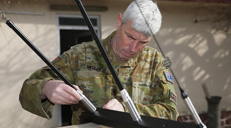 Australian Army officer Lieutenant Colonel Jason Medley prepares to install a Slivershield electronic force protection system, designed for the Afghan National Defence and Security Forces to counter radio-controlled improvised explosive devices. Photo by Sergeant Max Bree.