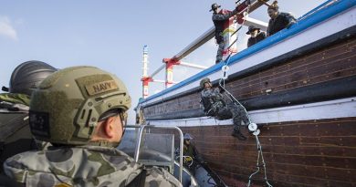 HMAS Warramunga boarding team member Able Seaman Aaron Richardson climbs onto a vessel of interest. Photo by Leading Seaman Tom Gibson.