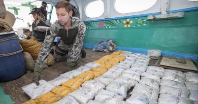 A sailor from Royal Australian Navy ship HMAS Warramunga prepares to remove packages of heroin from a dhow during a boarding operation. Photo by Leading Seaman Tom Gibson.