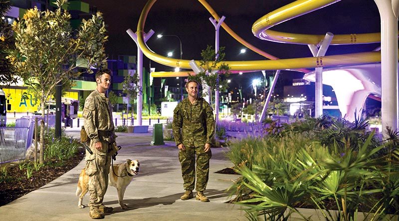 New Zealand Army Explosive Detection Dog Handler Acting Corporal Thomas Hynes (left) along with Australian Army 2nd Combat Engineer Regiment Sapper Guy Phillips, walk through the Athlete’s Village, during a search of the venue for the 2018 Gold Coast Commonwealth Games. ADF photo.