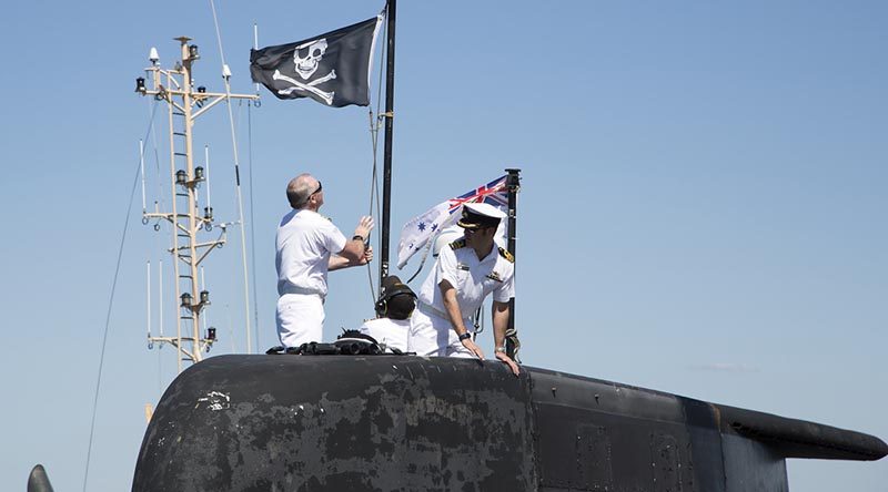 Executive Officer HMAS Dechaineux Lieutenant Commander Darren White raises the 'Jolly Roger' on Collins-class submarine HMAS Dechaineux at Fleet Base West. Official Defence photo by Chief Petty Officer Damian Pawlenko.