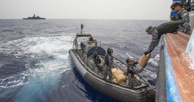 Leading Seaman James Walker (right) passes a parcel of seized narcotics to Able Seaman Stephanie Pannell during a drug-seizure operation in the Middle East. Photo by Leading Seaman Tom Gibson.