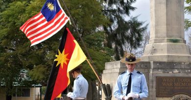 Australian Air Force Cadets CCPL Levi Schubert and CCPL Simon Russell from 604 Squadron Rest on Arms Reversed under the flags of Malaysia and Sarawak. Photo by Flying Officer (AAFC) Paul Rosenzweig