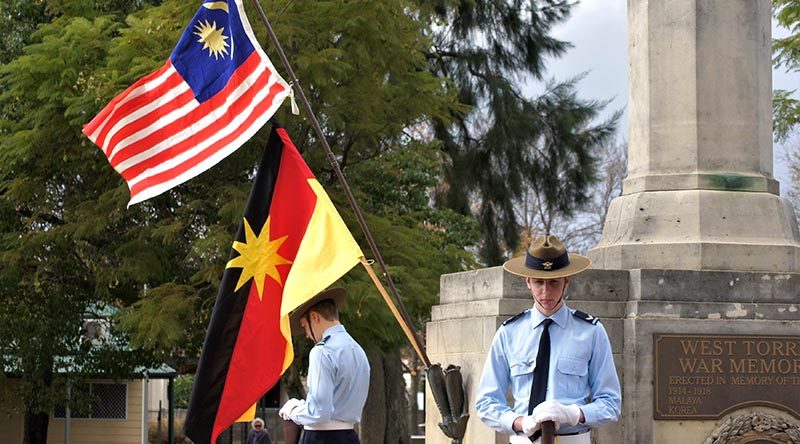 Australian Air Force Cadets CCPL Levi Schubert and CCPL Simon Russell from 604 Squadron Rest on Arms Reversed under the flags of Malaysia and Sarawak. Photo by Flying Officer (AAFC) Paul Rosenzweig