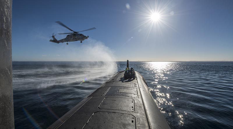 HMAS Ballarat's MH-60R Seahawk conducts a forward passenger transfer with HMAS Rankin in Western Australia, before the submarine departs for RIMPAC18. Photo by Able Seaman Grahame Kelaher.