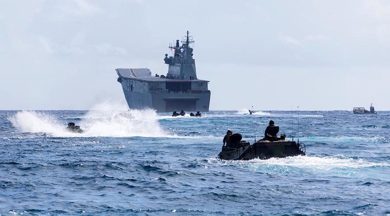 United States Marine Corps amphibious assault vehicles in Kaneohe Bay, Hawaii, prepare to enter HMAS Adelaide's well deck at sea during Exercise Rim of the Pacific 18. Photo by Corporal Kyle Genner.