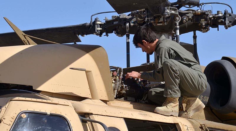 An Afghan Air Force member inspects a UH-60 Black Hawk at Kandahar Air Field, Afghanistan, as air crews prepare for their first Afghan-led operational mission on this aircraft type. US Air Force photo by 1st Lieutenant Erin Recanzone.