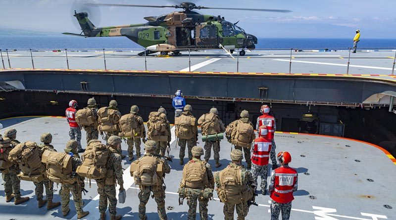 United States Marines prepare to board HMAS Adelaide's MRH-90 helicopter in support of amphibious operations off the coast of Hawaii, as part of Exercise RIMPAC 2018. Photo by Able Seaman Ronnie Baltoft.