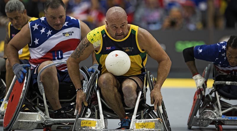 Australian Invictus team member Peter Arbuckle contests the ball during the wheelchair rugby bronze-medal play-off match against the United Stags during the Invictus Games in Toronto, Canada. Photo by Leading Seaman Jason Tufrey.