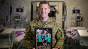 Australian Army Lieutenant Shane Balcombe displays a photo of his three boys, at Taji Military Complex, Iraq. Photo by Corporal david Said.