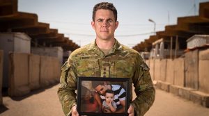 Australian Army Captain Evan Smith holds a photo of his son at Taji Military Complex, Iraq. Photo by Corporal David Said.