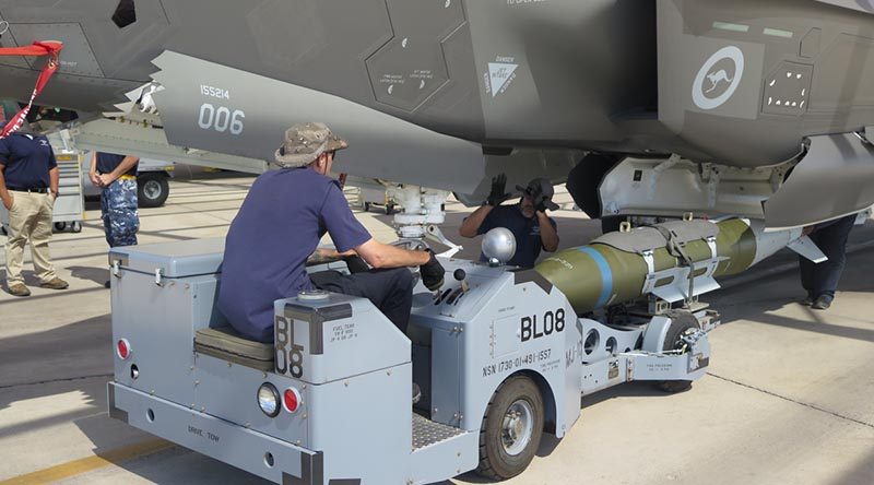 Lockheed Martin personnel load one of the first inert GBU-31 guided bombs into an Australian F-35A Joint Strike Fighter. Photo by Larone Thomas.