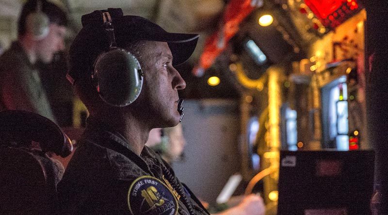 Royal Australian Air Force Warrant Officer David Bradshaw monitors a radar onboard an AP-3C Orion during a night exercise in the Philippines. Photo by Leading Seaman Jake Badior.