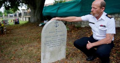Warrant Officer Ken Bancroft who is leading the vigil team of Royal New Zealand Navy sailors in England, examines the headstone of Engine Room Artificer Apprentice Philip Short, 20, who was killed in a vehicle accident and buried in England in 1958. NZDF photo.