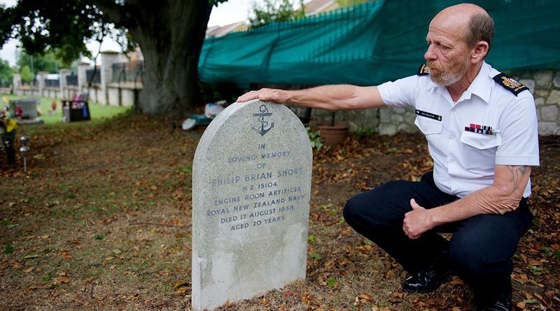 Warrant Officer Ken Bancroft who is leading the vigil team of Royal New Zealand Navy sailors in England, examines the headstone of Engine Room Artificer Apprentice Philip Short, 20, who was killed in a vehicle accident and buried in England in 1958. NZDF photo.