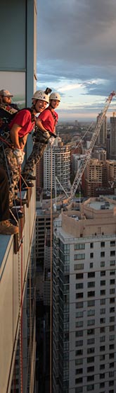 Able Seaman Madeline Whatley and Able Seaman Savannah Tansey prepare to abseil from a Sydney skyscraper.