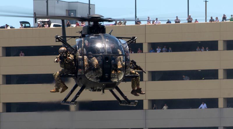 Special operations operators onboard an MH-6 Little Bird helicopter assault a simulated enemy position in an urban setting during a capabilities demo at the 2018 International Special Operations Forces week in Tampa, Florida. Photo by US Air Force Master Sergeant Barry Loo.