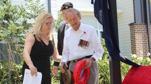 Gordon Jamieson lay a wreath at Carinity Cedarbrook at Mudgeeraba, Queensland, assisted by Wendy Kane and Rye Stott.