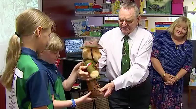 Keith Payne VC hands Trooper Bert Jones over to students at Dundula State School in Baker’s Creek, Queensland, to use as a teaching aid and an Anzac reminder. Screen grab from Channel 7 news report.