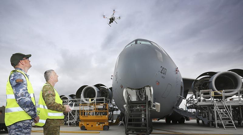 Australian Army Sergeant Andrew Whitelaw, from 16 Air Land Regiment and Corporal Kelvin Green, Aircraft Surface Finisher at Royal Australian Air Force No.36 Squadron, launch a drone to inspect the condition of paint on the upper surfaces of a C-17A Globemaster at RAAF Base Amberley. Photo by Corporal Kylie Gibson.