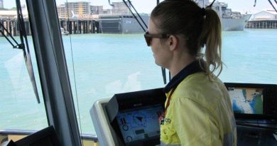 Darwin-based tugboat driver Alicia Pollock in Darwin Harbour (with Singapore's Endurance-class landing ship tank RSS Endeavour docked in the background). Serco photo.