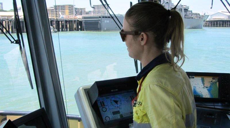 Darwin-based tugboat driver Alicia Pollock in Darwin Harbour (with Singapore's Endurance-class landing ship tank RSS Endeavour docked in the background). Serco photo.