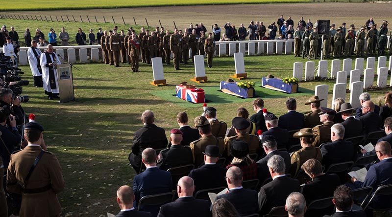 The caskets of unknown First World War Australian and British soldiers lie next to their headstones, during a burial ceremony at Tyne Cot Cemetery, Belgium. Photo by Corporal Jake Sims.