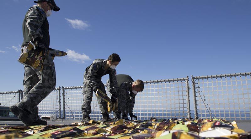 Members of HMAS Ballarat’s boarding party lay out seized narcotics in preparation for disposal in the Middle East. Photo by Leading Seaman Bradley Darvill.