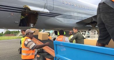 Flight Lieutenant Sam Hatrick, aircraft captain from the Royal New Zealand Air Force’s No.40 Squadron, helps offload about two tonnes of voting equipment and operational supplies for The Fred Hollows Foundation New Zealand from an RNZAF Boeing 757 aircraft at Honiara. NZDF photo.