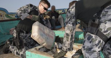 Leading Seaman Aaron Wheeler pulls a sack containing suspected illegal narcotics from the hold in a dhow. Photo by Leading Seaman Bradley Darvill.