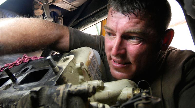 Royal Australian Electrical and Mechanical Engineer vehicle mechanic Craftsman David Butler replacing a starter motor on an Australian Light Armoured Vehicle in Iraq. Photo by Corporal Rob Nyffenegger.