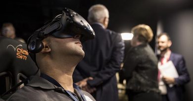 Vikas Nayak, Systems Integrator Lockheed Martin Australia, demonstrates Phase 1 of Joint Project 9711 Core Simulation Capability at Lockheed Martin Australia in Canberra, while VIP visitors chat in the background. Lockheed Martin photo.