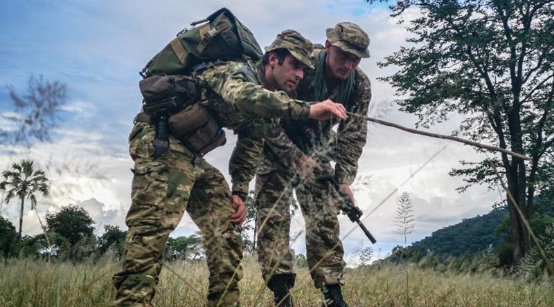 Lance Corporal Jed Maskill (left), from 1 RNZIR, teaches tracking tactics to a British Army soldier in Malawi. NZDF photo.