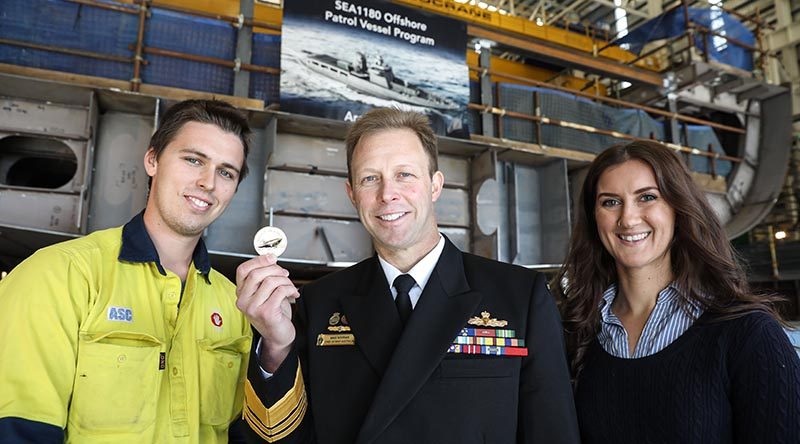 Boilermaker Kane Ramsay and Document Editor Lauren Pitman prepare to assist Chief of Navy Vice Admiral Michael Noonan to lay a traditional coin under the keel of the future HMAS Arafura. Photo supplied by ASC.