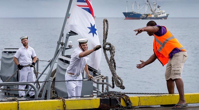 A sailor on HMAS Gascoyne throws a line to a Funafuti wharf worker as the ship pulls alongside in Tuvalu during a south-west-Pacific-engagement tour. Photo by Leading Seaman Craig Walton.