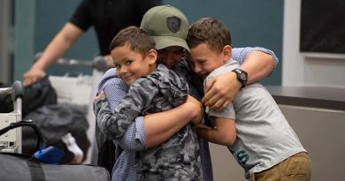 A New Zealand Defence Force soldier returning home after a six-month deployment in Iraq hugs his two sons upon arrival at Royal New Zealand Air Force Base Ohakea this afternoon. NZDF photo.