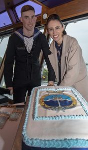 Prime Minister Jacinda Ardern and the youngest member of the crew, Able Rate Angus Dorahy, cut the commissioning cake aboard HMNZS Manawanui. NZDF photo.