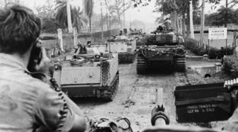 Centurion tanks from 1st Armoured Regiment, and armoured personnel carriers from B Squadron, 3rd Cavalry Regiment, move along the main road of Binh Ba village. Over three days, armour and infantry dislodged a strong North Vietnamese Army group that had entered the village, for the loss of one Australian killed in action. AWM BEL/69/0389/VN. Binh Ba.