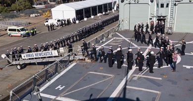 HMAS Newcastle's decommissioning crew march off their ship for the last time.