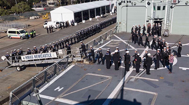 HMAS Newcastle's decommissioning crew march off their ship for the last time.