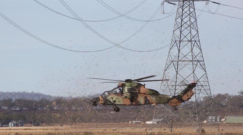 An ARH Tiger from the Army Aviation Training Centre at Oakey practices flying under-wires. The ability for the aircraft to use terrain masking greatly increases survivability against an enemy with advanced weaponry, increasing lethality and reconnaissance ability. Photo by Bradley Richardson.