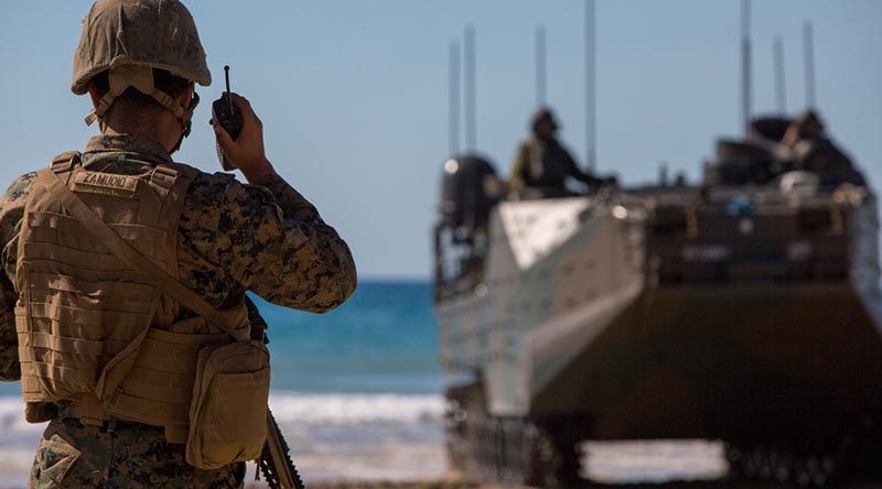 A US Marine speaks on a radio during the Combined Force Entry Operation during Exercise Talisman Sabre 19 during an amphibious landing at Stanage Bay, Queensland. US Marine Corps photo by Lance Corporal Kaleb Martin.