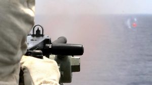 Seaman Boatswains Mate Phillip Hughes engages a 'Killer Tomato' inflatable target with a Browning 12.7mm Quick Change Barrel Heavy Machine Gun from the upper decks of HMAS Sydney. Imagery by Leading Seaman Peter Thompson.