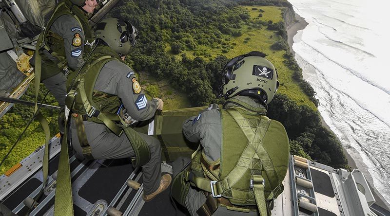 Corporal Toni Thompson, Sergeant Ethan Moran and Corporal Nicholas Morse, Royal New Zealand Air Force air loadmasters with No.40 Squadron, watch a parachute load fall to its target on Raoul Island off the their C-130H(NZ) Hercules. RNZDF photo.