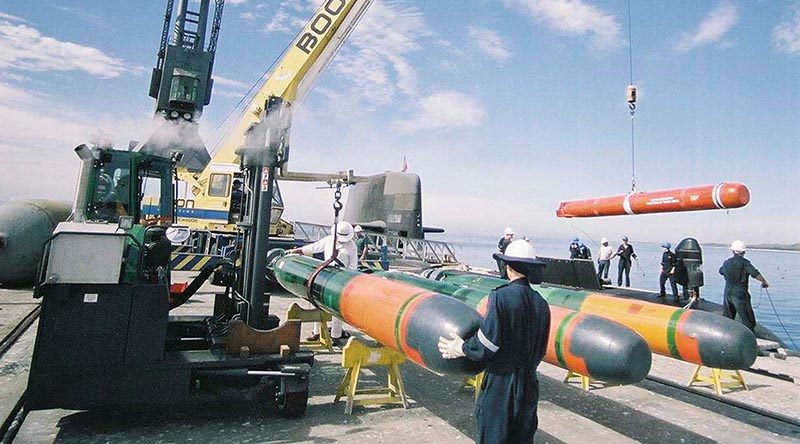 HMAS Dechaineux takes on training torpedoes at the ammunition wharf at HMAS Stirling. Photo by Able Seaman Photographer Phillip Cullinan.