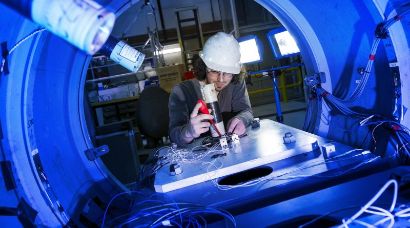 Steven De Candia, a PhD candidate and mechanical engineer, prepares instrumentation for an experiment on a submarine structural test model at Defence Science and Technology facility, Fishermans Bend, Melbourne. Photo by Lauren Larking.