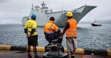 Port of Suva workers watch as Canberra-class Landing Helicopter Dock HMAS Adelaide (III) prepares to come alongside at Kings Wharf in Suva, Fiji. Photo by Corporal Jessica de Rouw.